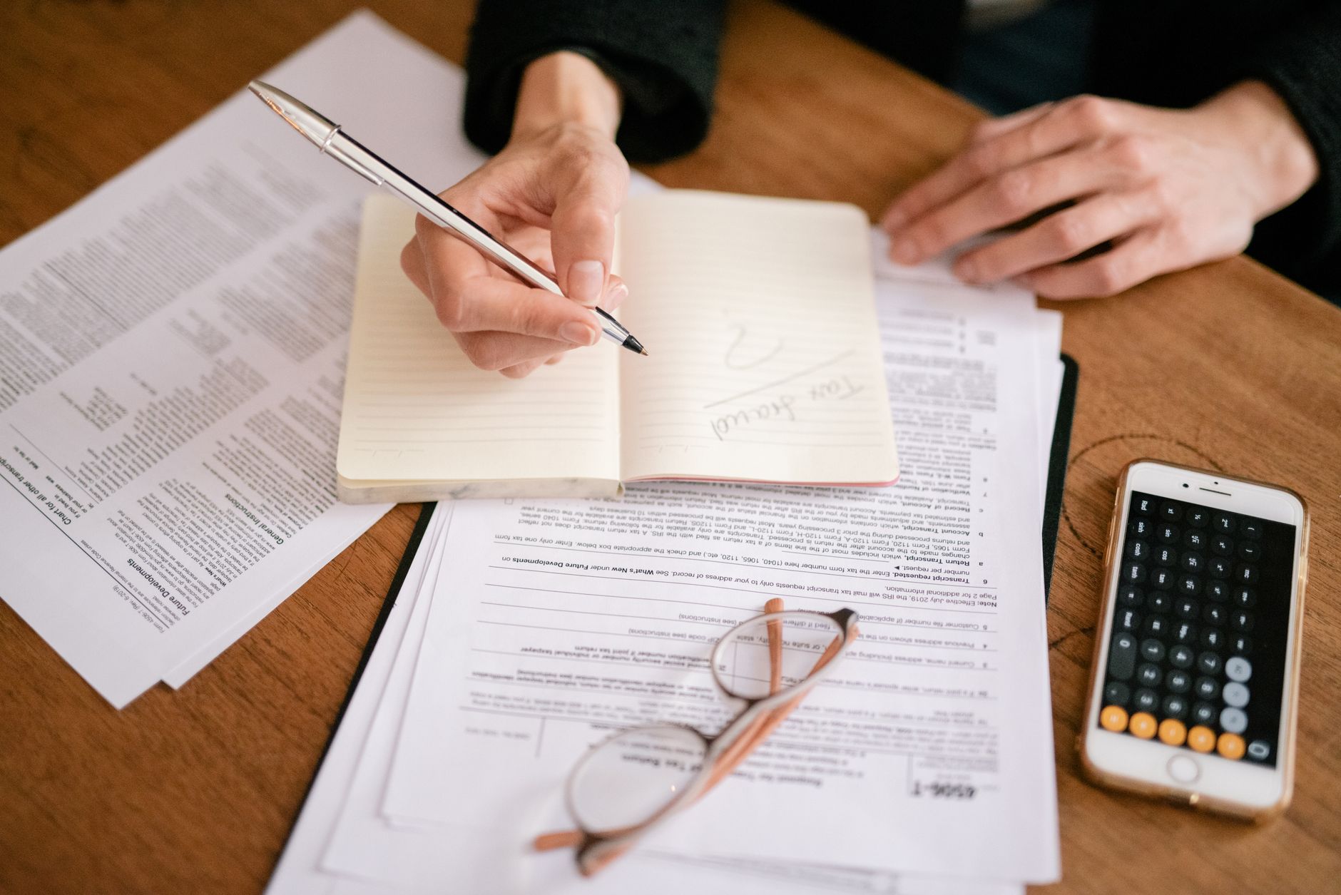 Tax documents and a calculator on a desk, the kind of paperwork an accounting firm's Google Ads landing page needs to make easy to hand off
