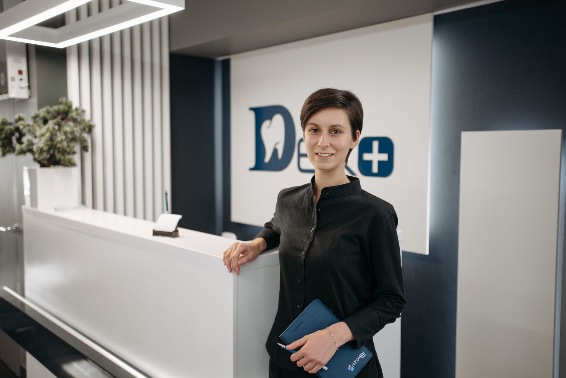 A dental clinic staff member working at the front desk, where a fast follow-up call closes the leads a Google Ads campaign generates