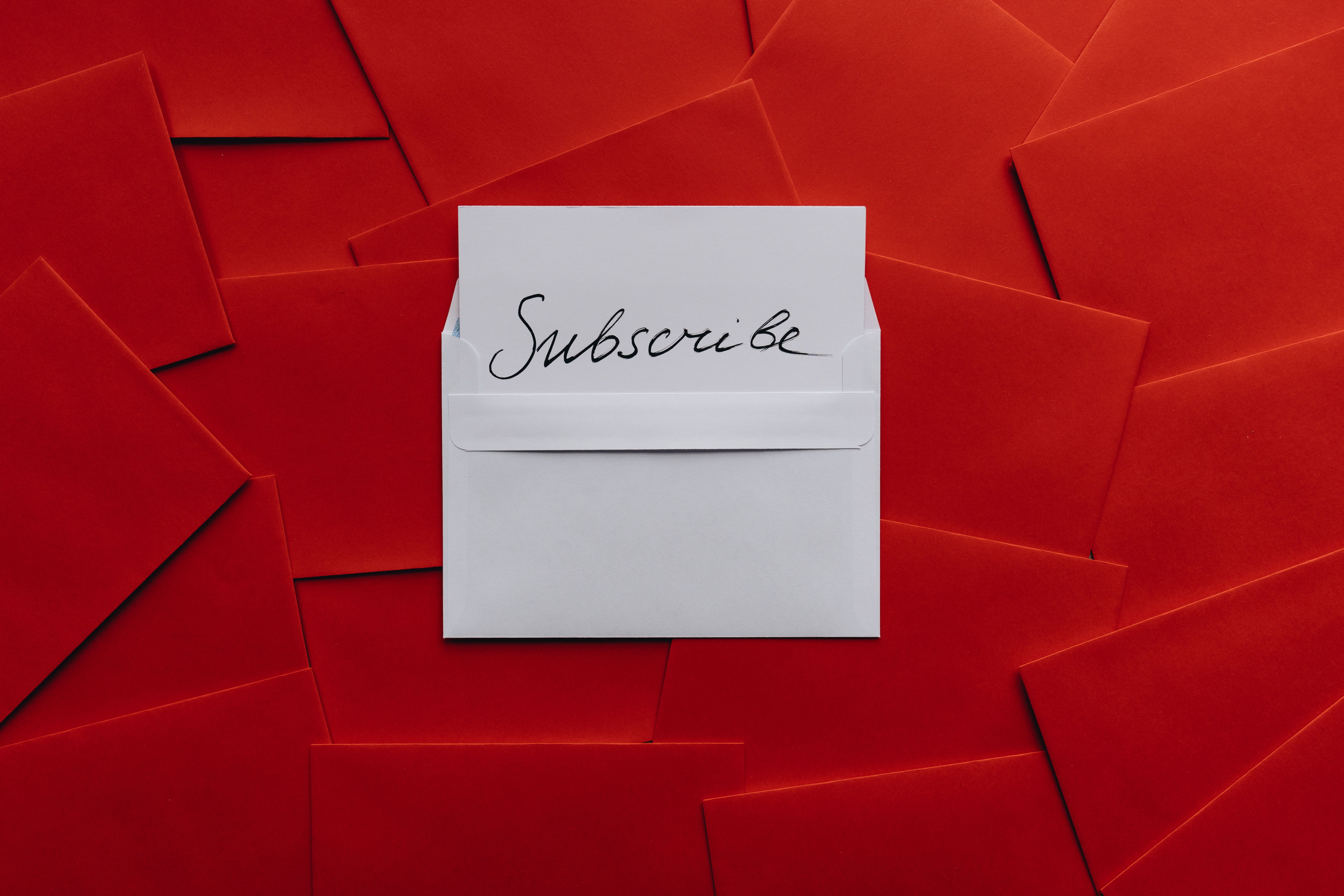 A white envelope reading 'Subscribe' among red envelopes, representing email marketing in Barrie