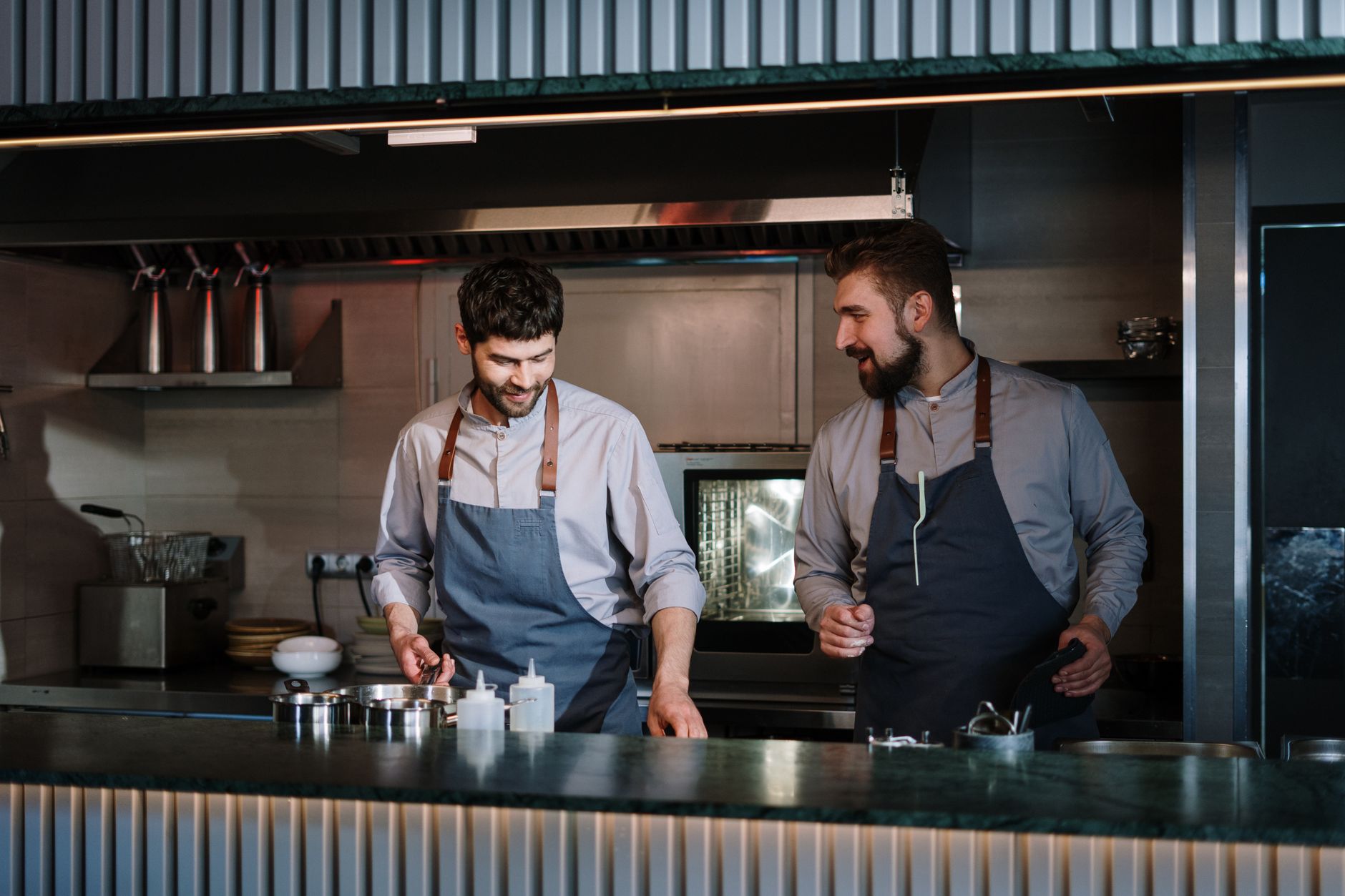 Two restaurant kitchen staff working together during service, the daily reality a Google Ads campaign for a Barrie restaurant has to keep booked