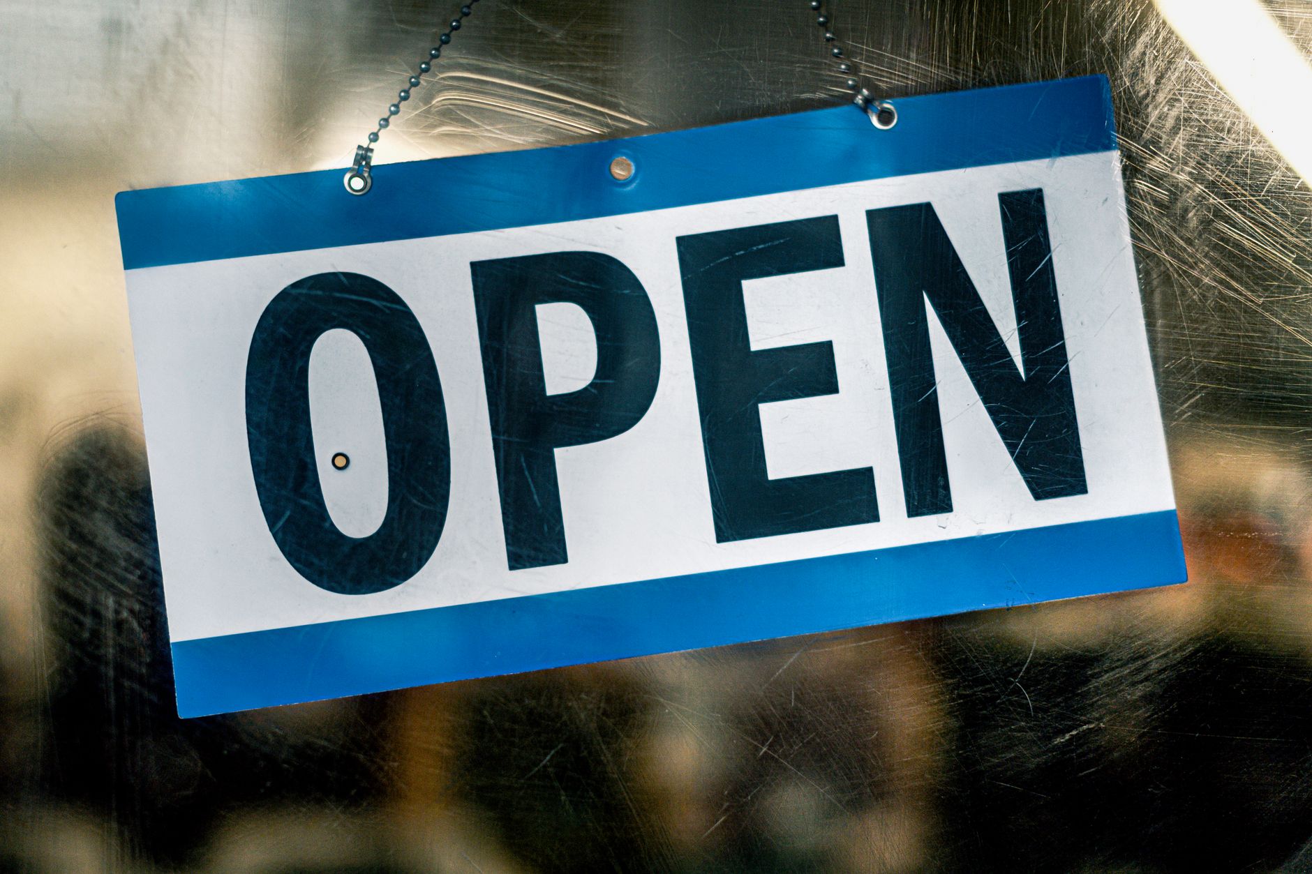 An "open" sign hanging in a small business storefront window — the kind of local business that shows up in the map pack once you optimize your Google Business Profile for local SEO