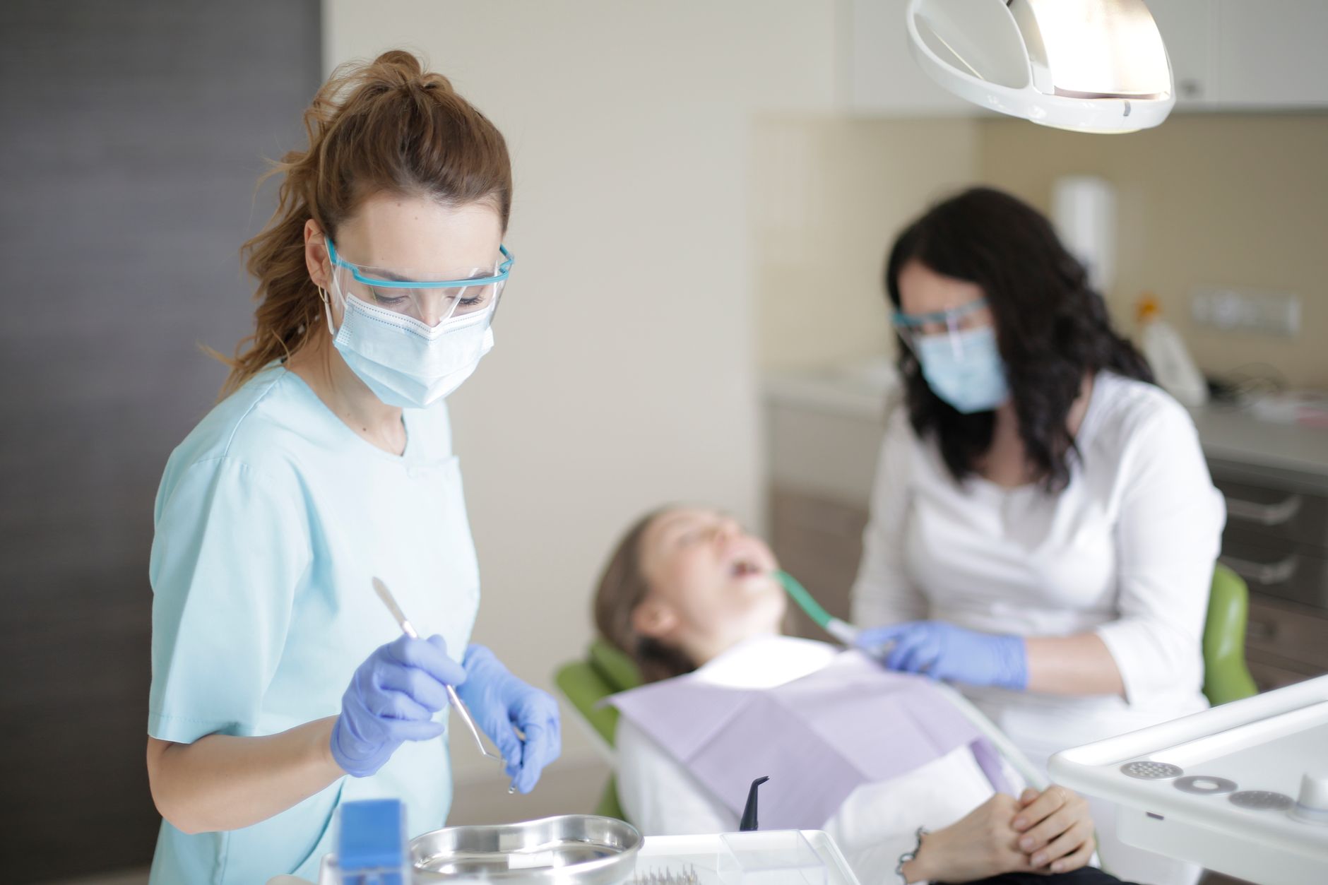 A dental team treating a patient in a bright clinic, local SEO for dentists in Newmarket starts with a practice patients can find