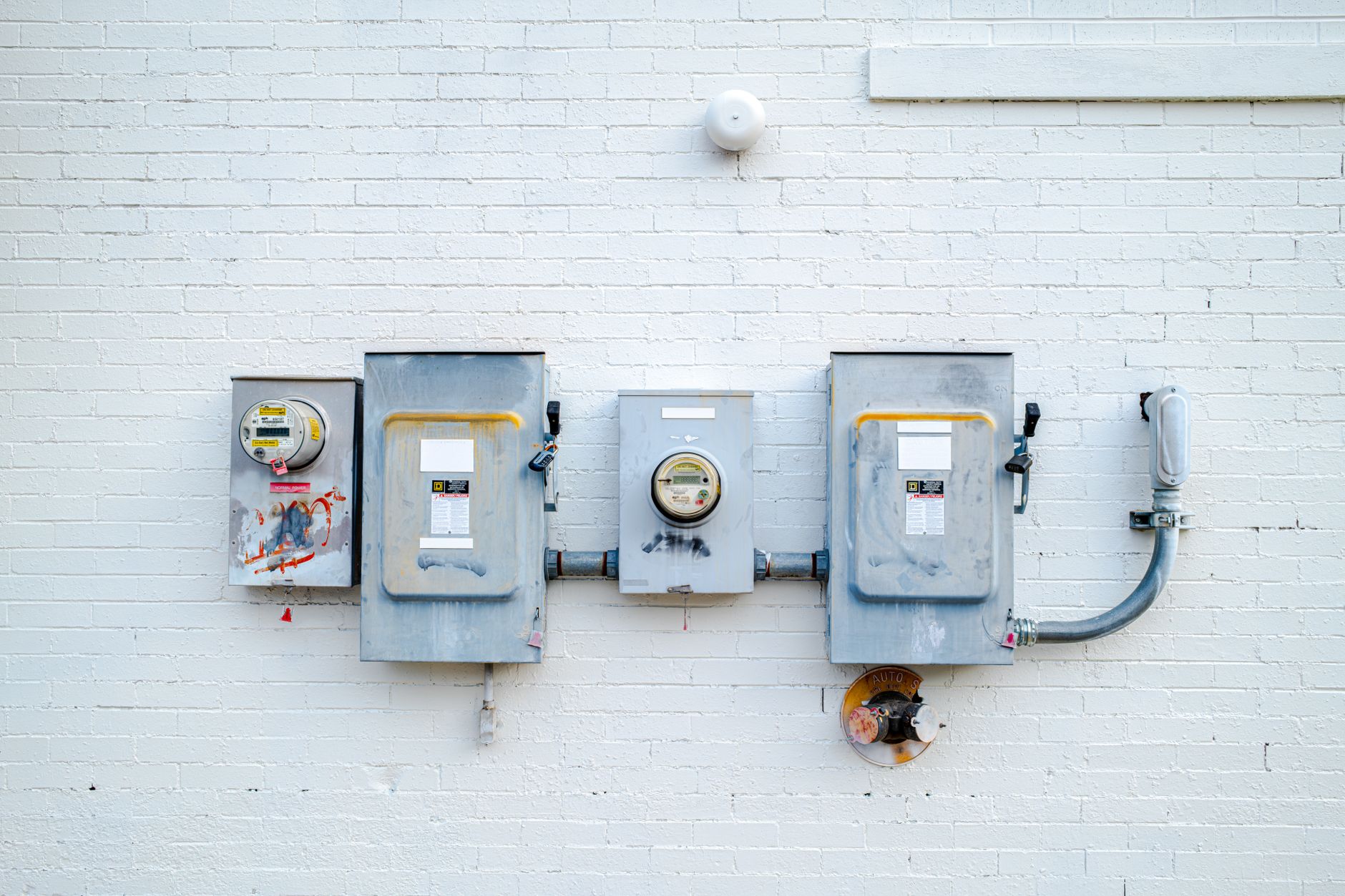 A row of exterior electrical meters and disconnect panels mounted on a wall, the type of panel work an Innisfil electrician's service pages should describe
