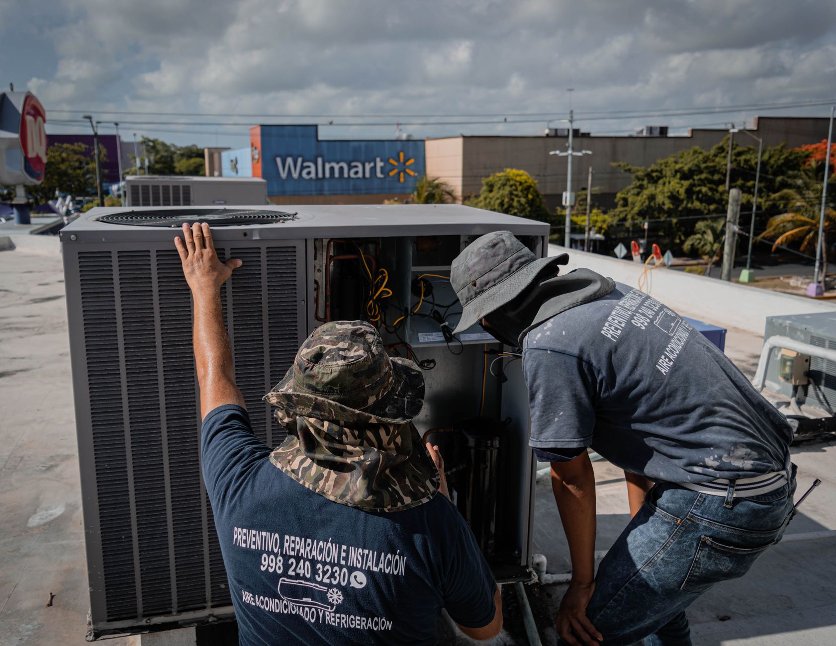 Two HVAC technicians in hi-vis workwear inspecting an open rooftop air conditioning unit — the kind of on-site work local SEO for HVAC companies in Barrie is built to generate calls for
