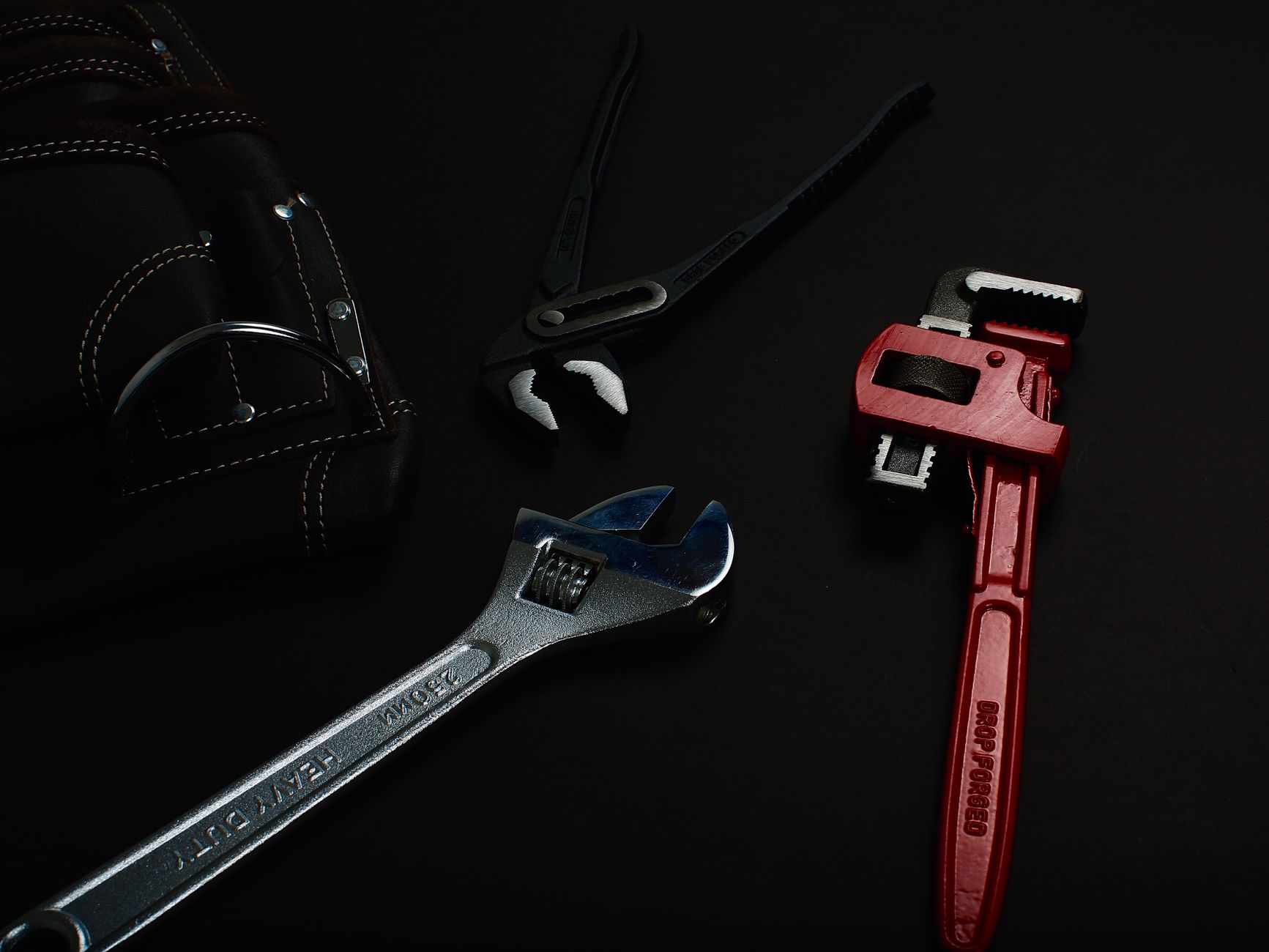 A close-up of a wrench and plumbing tools laid out for a repair job