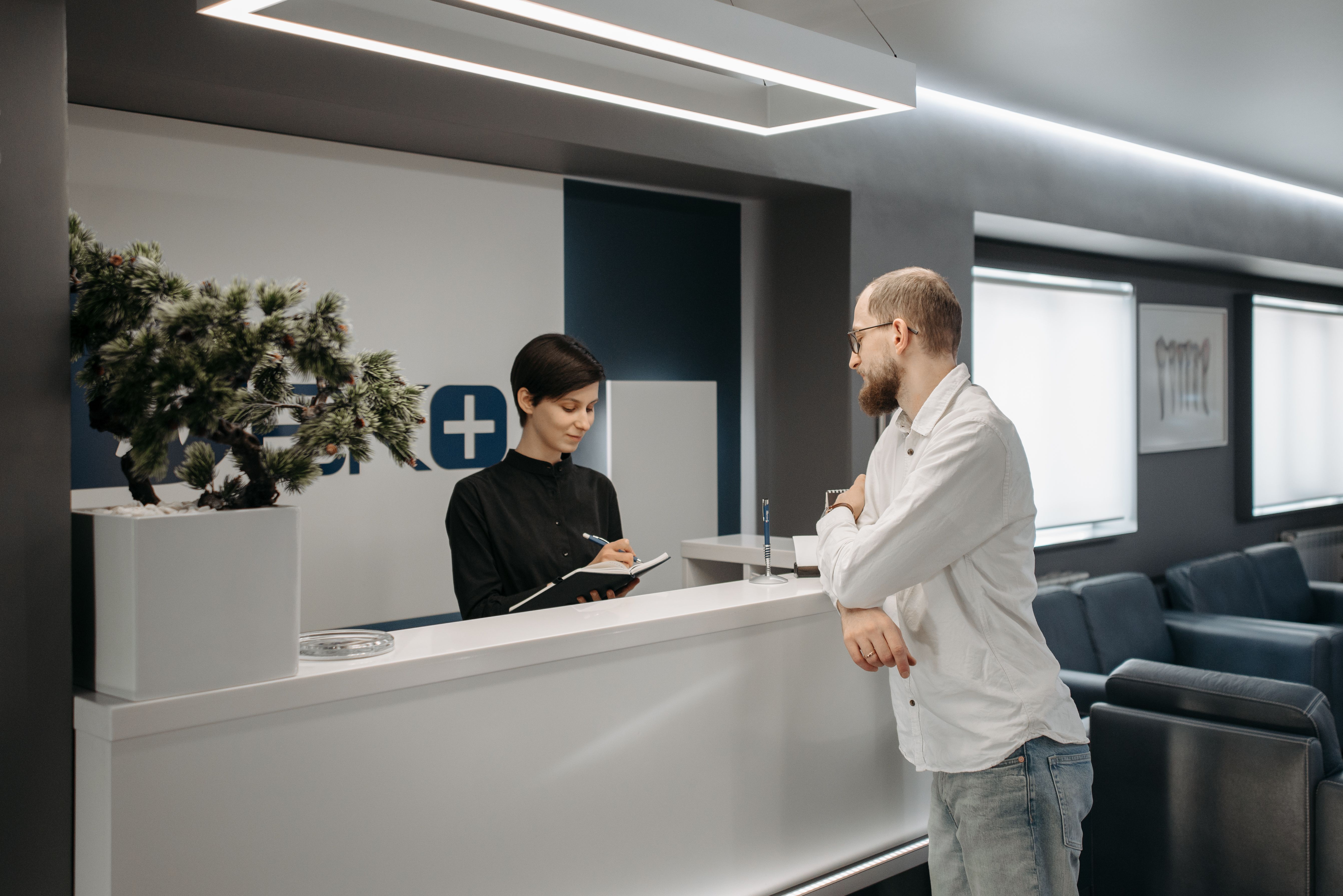 A patient checking in at a medical clinic's front reception desk