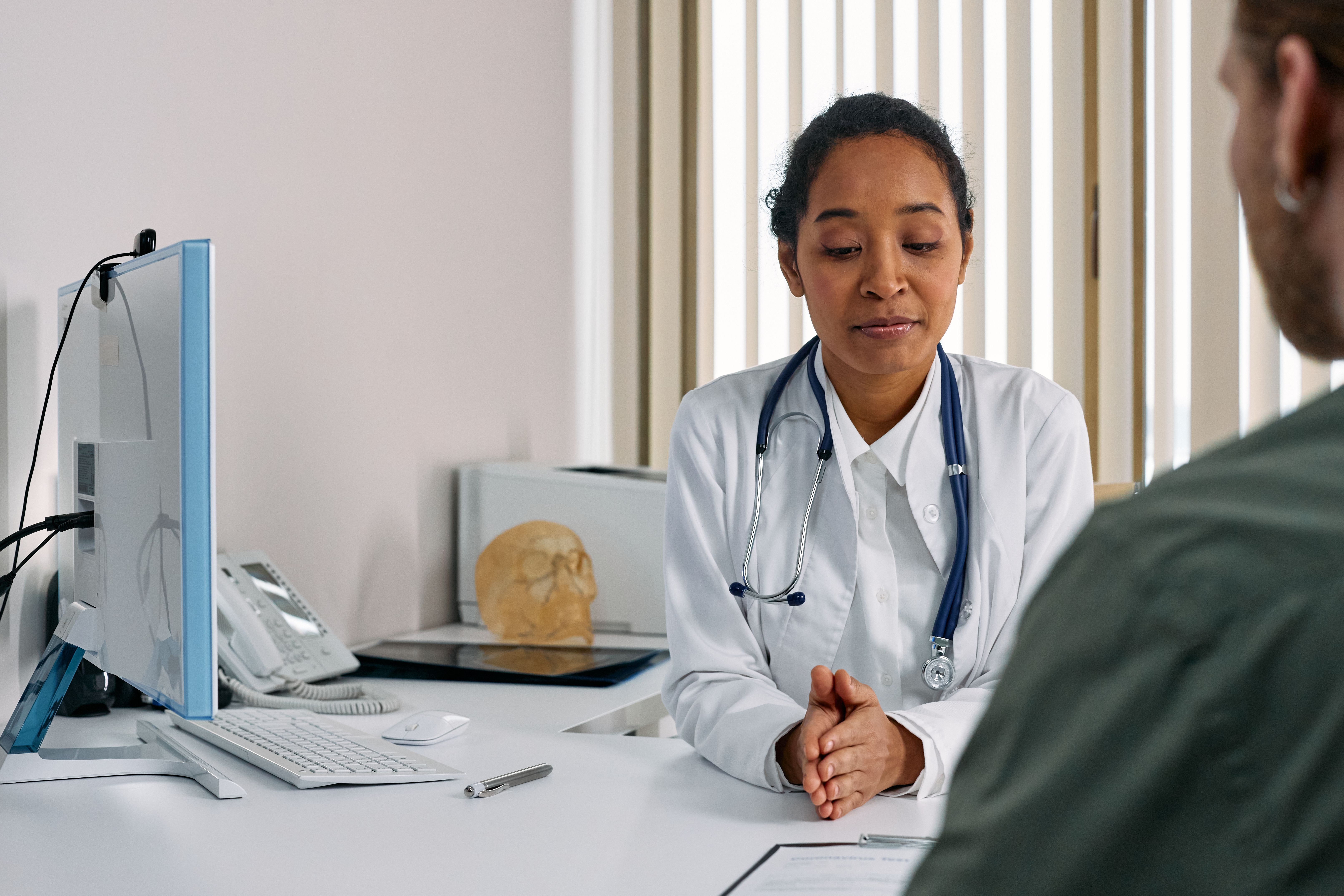 A doctor consulting face-to-face with a patient in an exam room, the kind of trust-building visit med care marketing is meant to fill more of