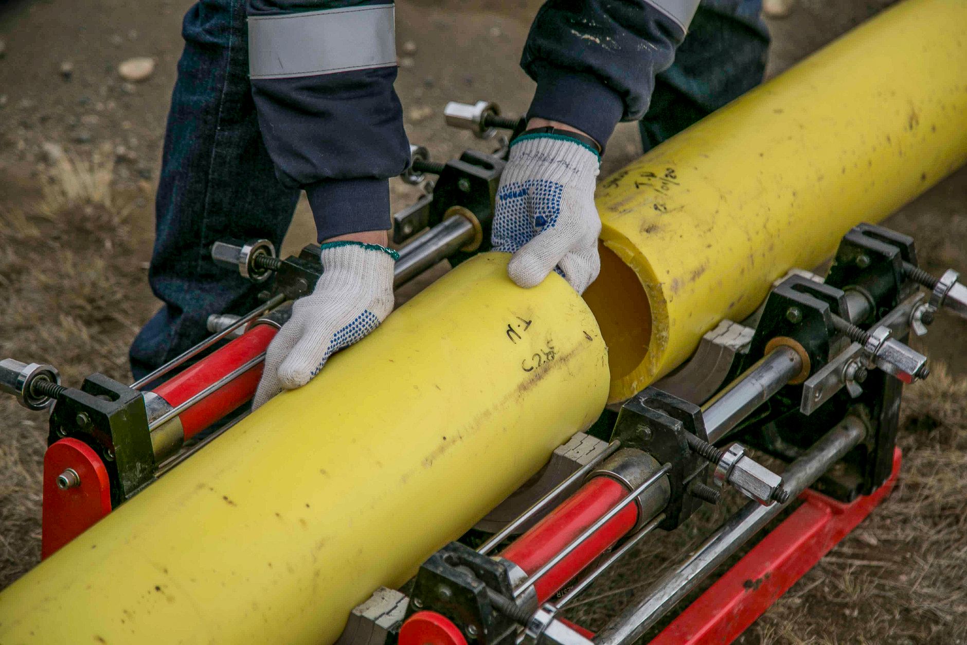 A plumber holding a bundle of yellow pipes on a job site, the kind of work plumber Google Ads in Barrie are meant to book