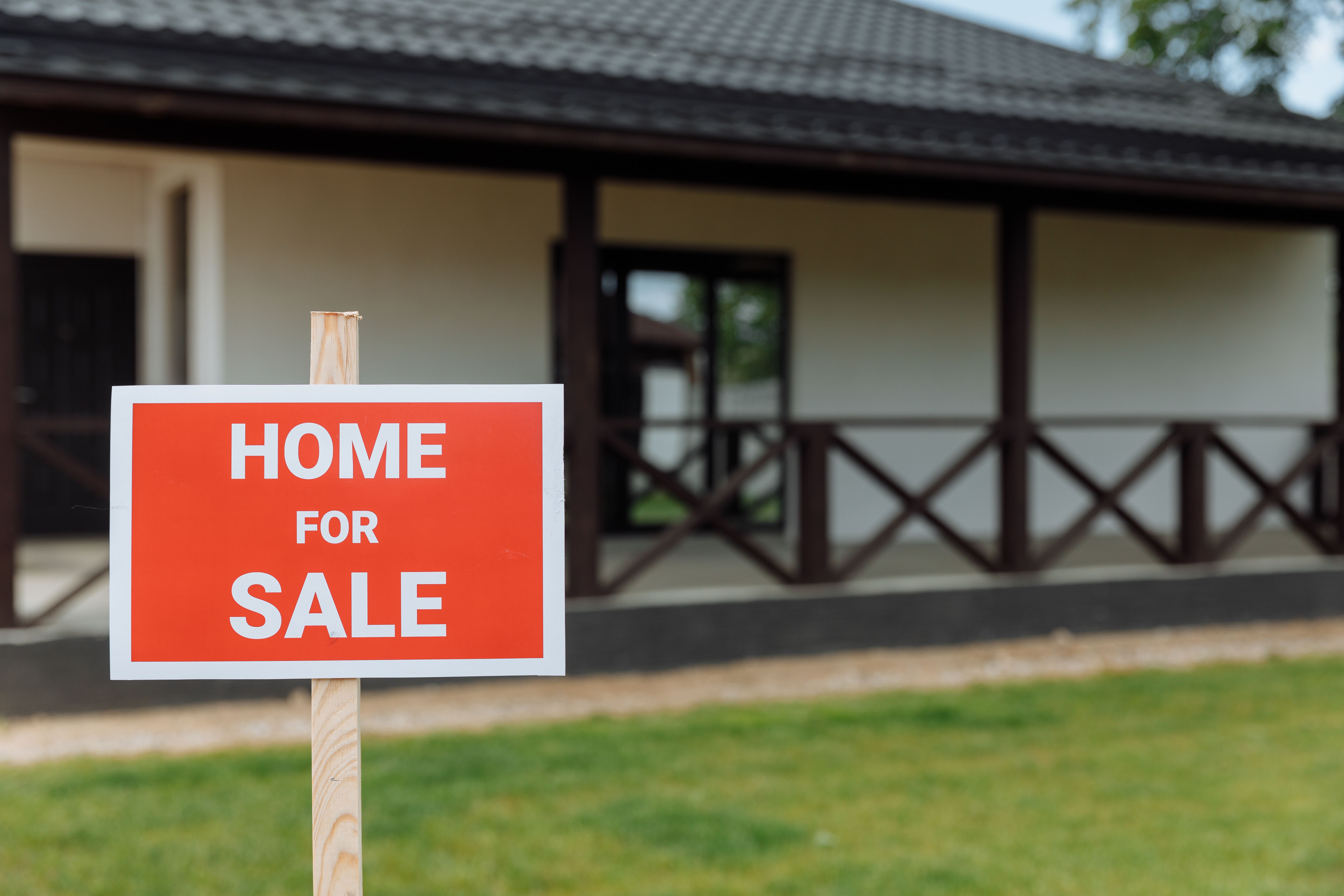 A red "for sale" sign posted outside a home, the kind of listing that starts a real estate lead gen inquiry