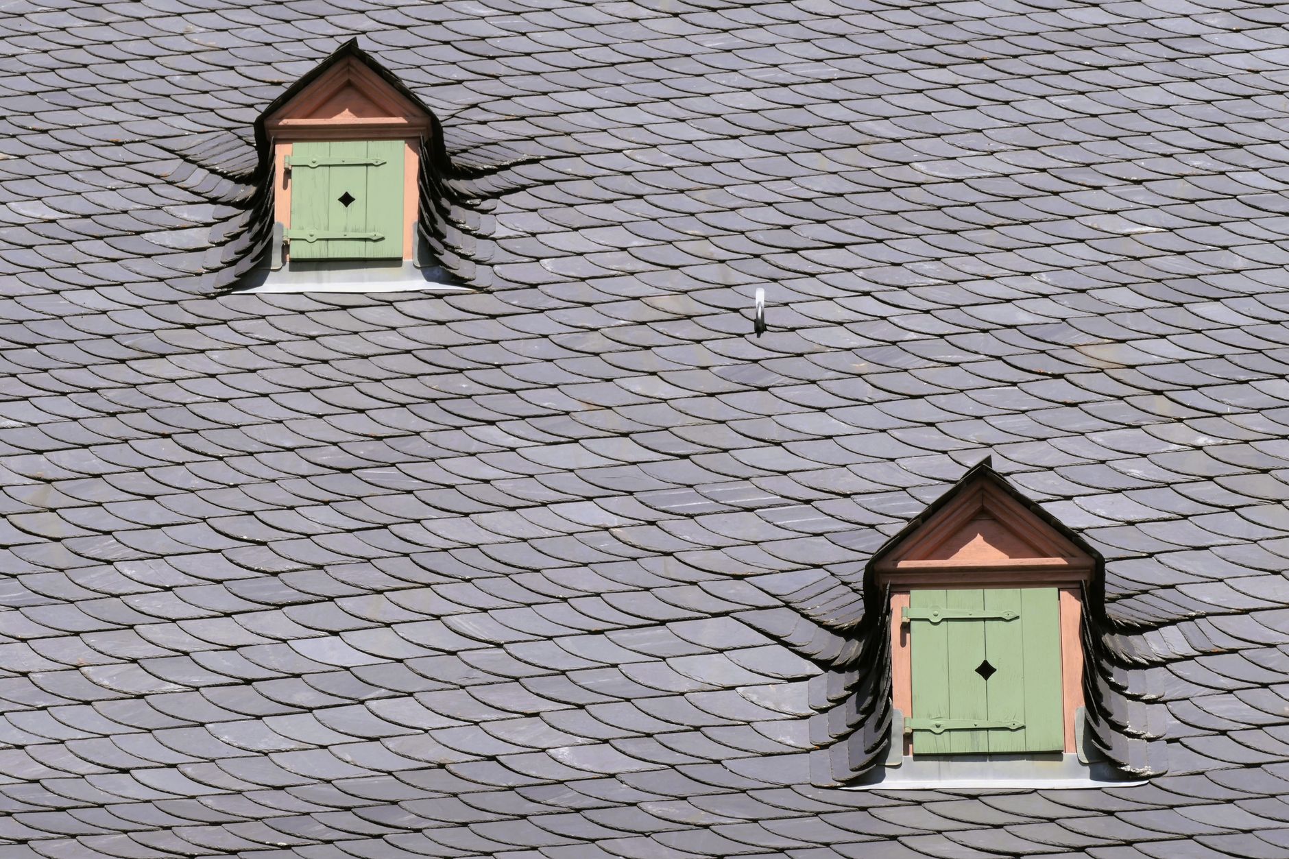 A slate roof with green shuttered dormers on a home: the kind of roofing work Thunder Bay contractors bid on with roofing Google Ads