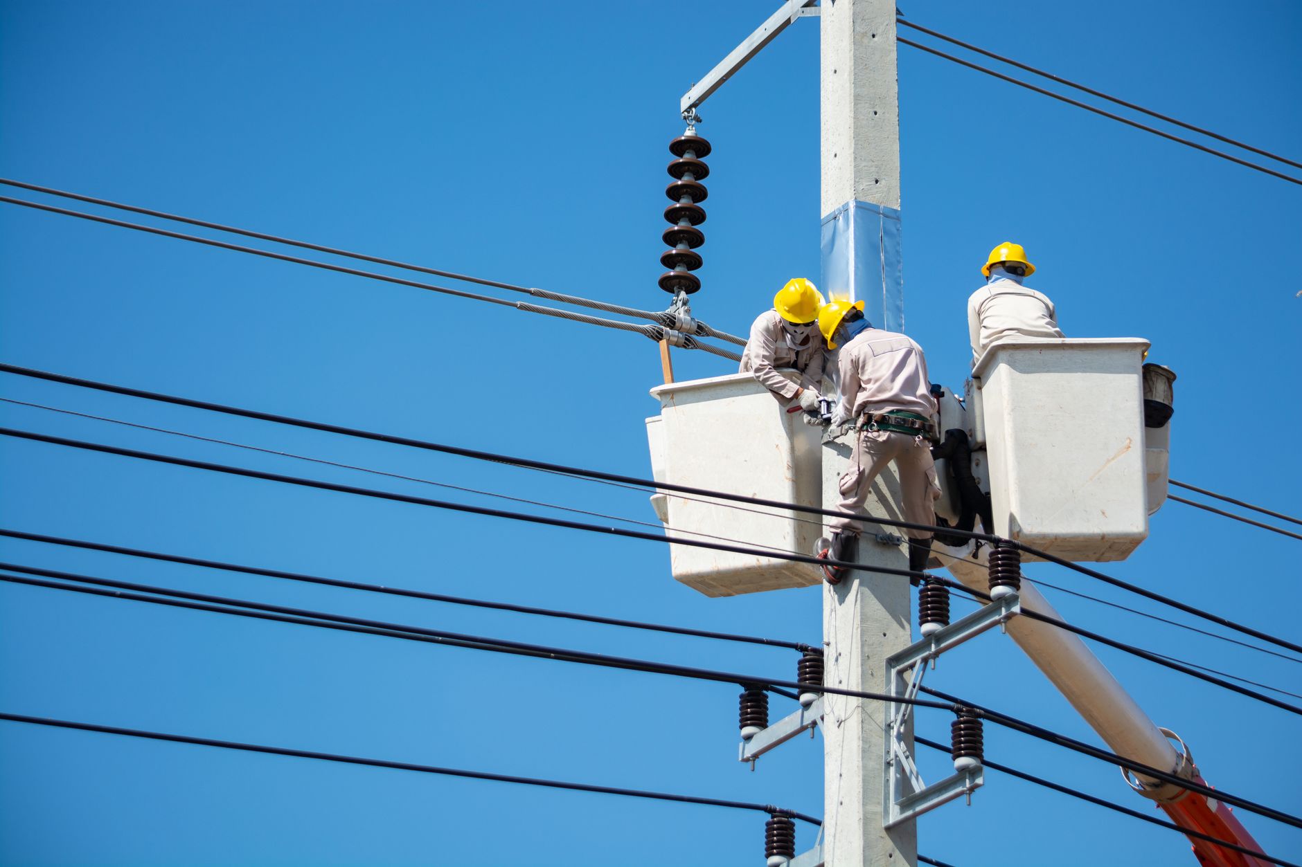 Electrical workers on a job site beside their service van, the kind of daily work an electrician's social media should show