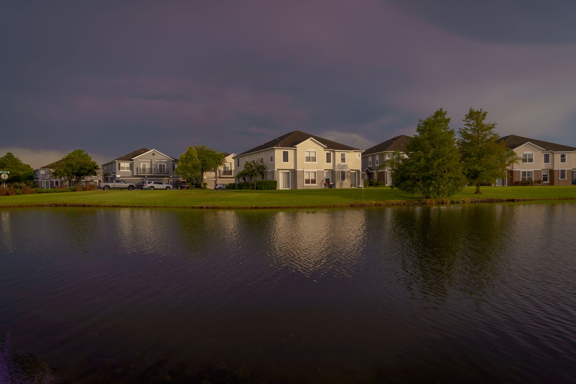 Houses lining the shore of a lake, the kind of waterfront street a neighbourhood video for real estate agents in Innisfil would cover